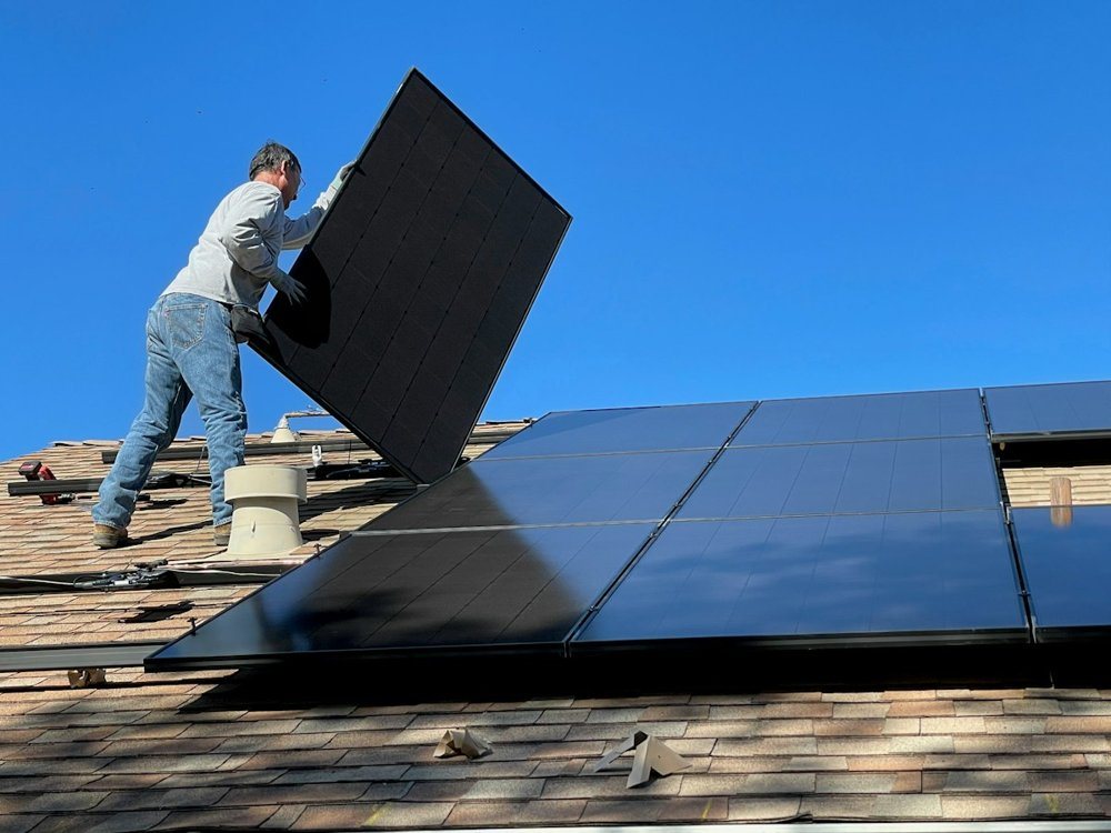 Installateur posant un panneau solaire sur une toiture